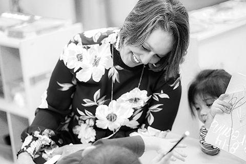 Deidre Anderson works with two kids at a small table.