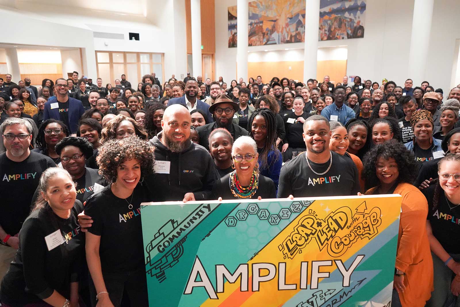 Educators of color gather behind the Amplify sign at a previous Amplify KC conference in Kansas City, Missouri.