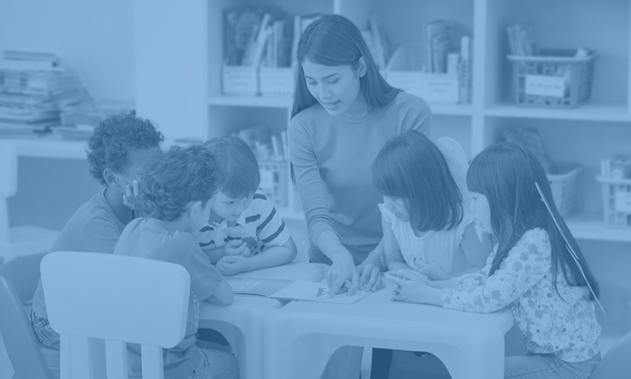 early educator teaches a group of students gathered around a table