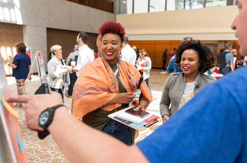 Two women smiling at a convening