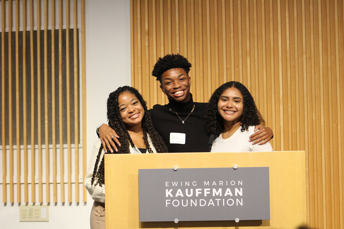 Three Piper High School presenters pose for a photo behind the podium at the Accelerate Conference.