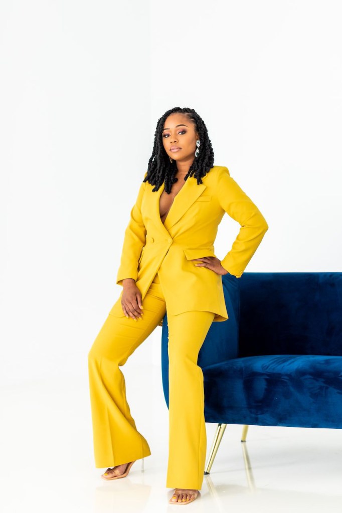 A photo of Sherrell Dorsey in a yellow pantsuit
