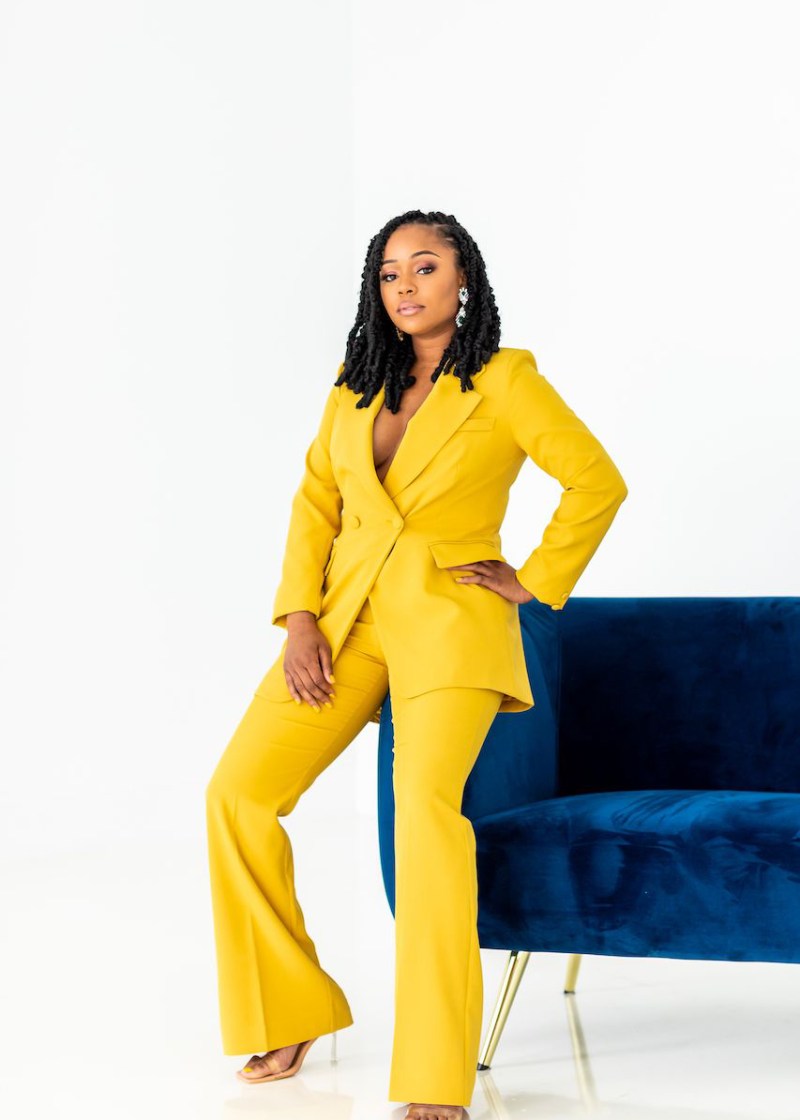 A photo of Sherrell Dorsey in a yellow pantsuit