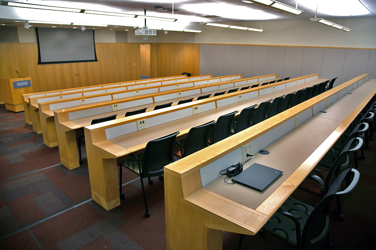 A tiered lecture conference room that seats 66 people. A standing podium is at the front of the room.