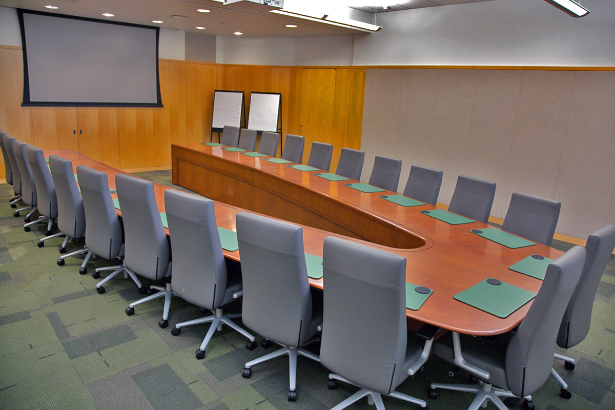 A conference room featuring a U-shaped board table seating 22 people.