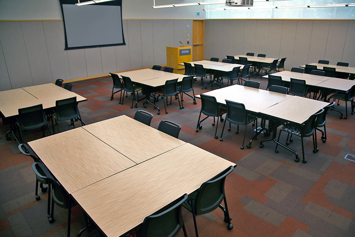 A larger conference room featuring classroom-style tables that seats 48 people. A standing podium is at the front.