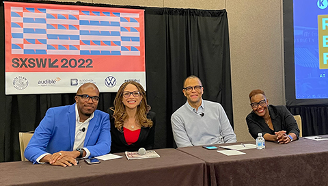 Four panelists pose for a photo at their table at SXSW 2022 in March.