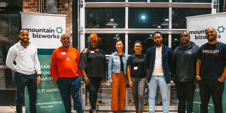 Eight people stand for a group photo in Asheville, North Carolina, at a Mountain BizWorks event.