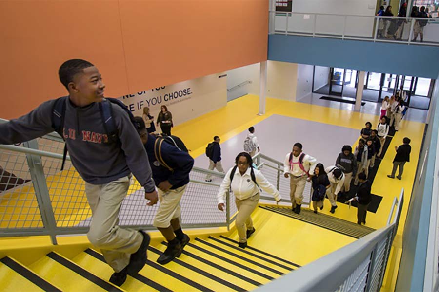 A group of students walk up the stairs at the Ewing Marion Kauffman School.