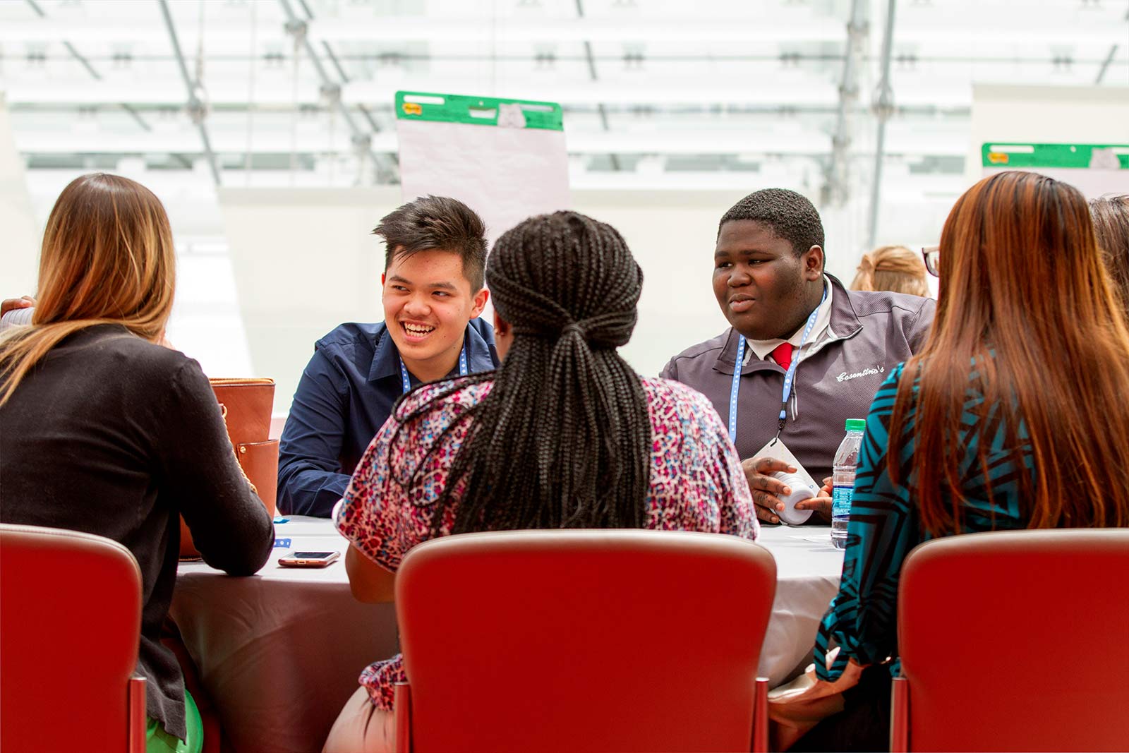 A group of students sit around a table at a learning conference.