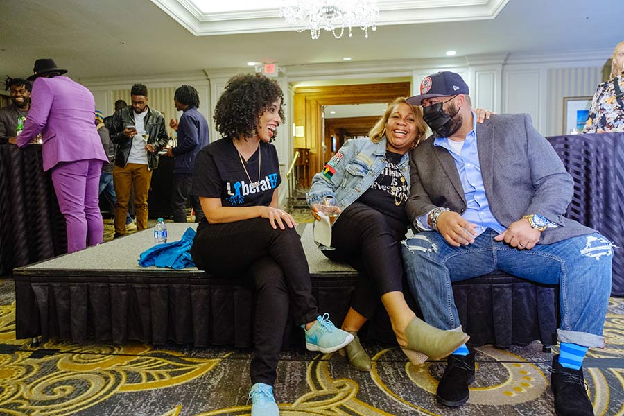Three educators of color attending the Amplify conference laugh together.