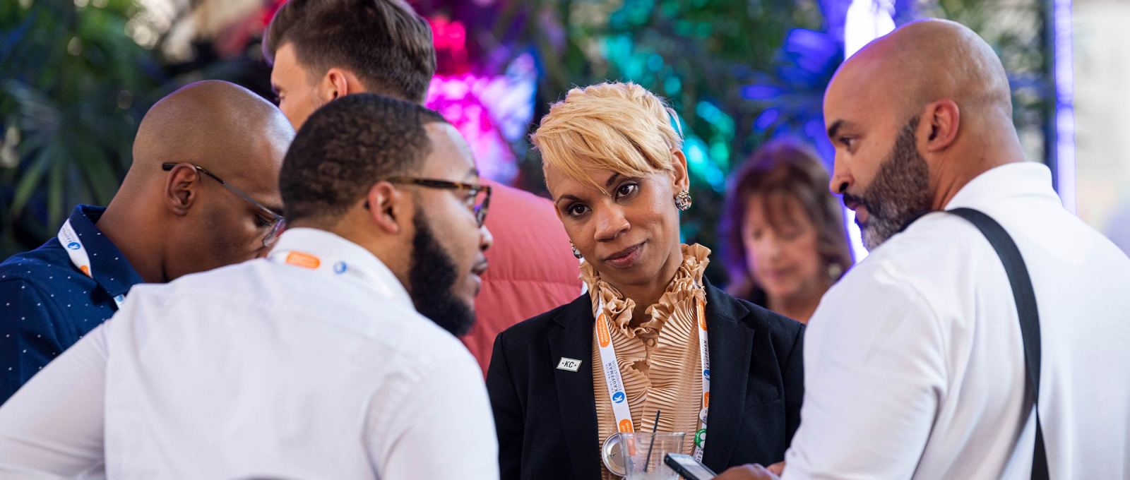 Four people of color engage in conversation, with other attendees in different conversations around them, at the 2019 ESHIP Summit conference in Kansas City, Missouri.