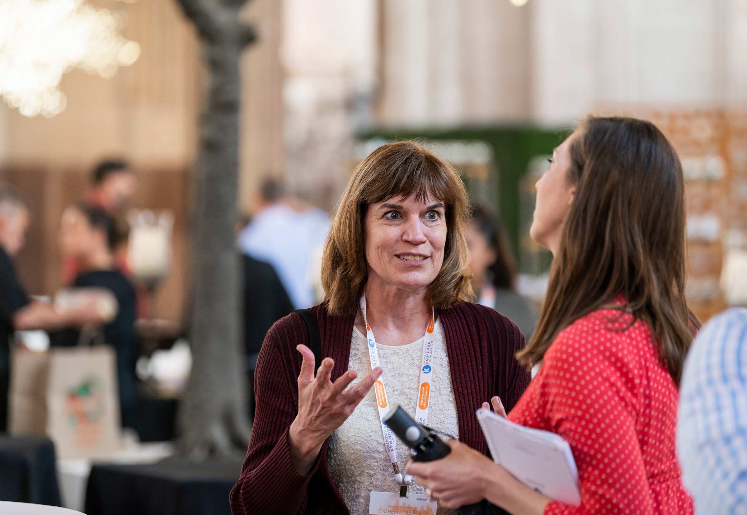 Two people engage in conversation at an ESHIP Summit/Mayors Conference event in Kansas City, Missouri.