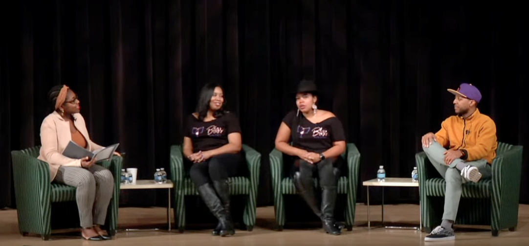 A panel of four Black entrepreneurs sit on stage