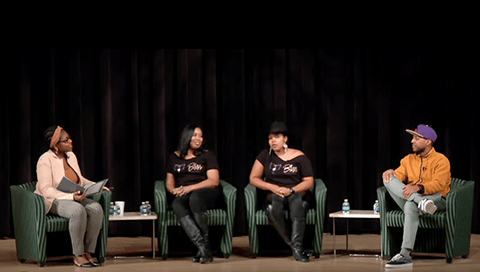 A panel of four Black entrepreneurs sit on stage