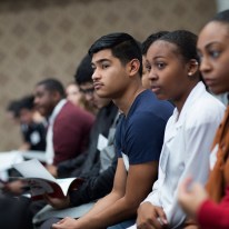 A group of young people sit side-by-side.
