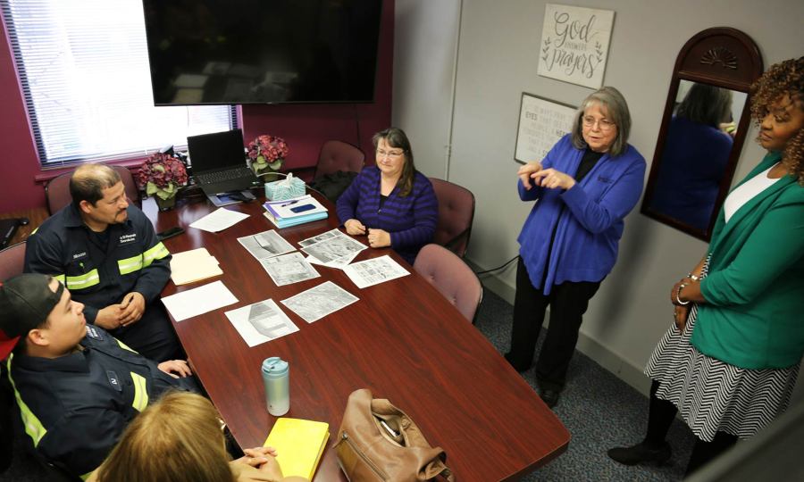 A group of people at Holy Rosary Credit Union in conversation around a conference table
