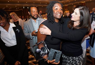 Fahteema Parrish, president and founder of Parrish & Sons Construction, holds the Mr. K Award she received at the KC Chamber Small Business Celebration, and is embraced by Lisa Ginter, CEO of Community America Credit Union.