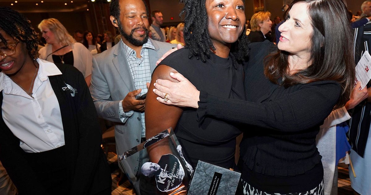 Fahteema Parrish, president and founder of Parrish & Sons Construction, holds the Mr. K Award she received at the KC Chamber Small Business Celebration, and is embraced by Lisa Ginter, CEO of Community America Credit Union.