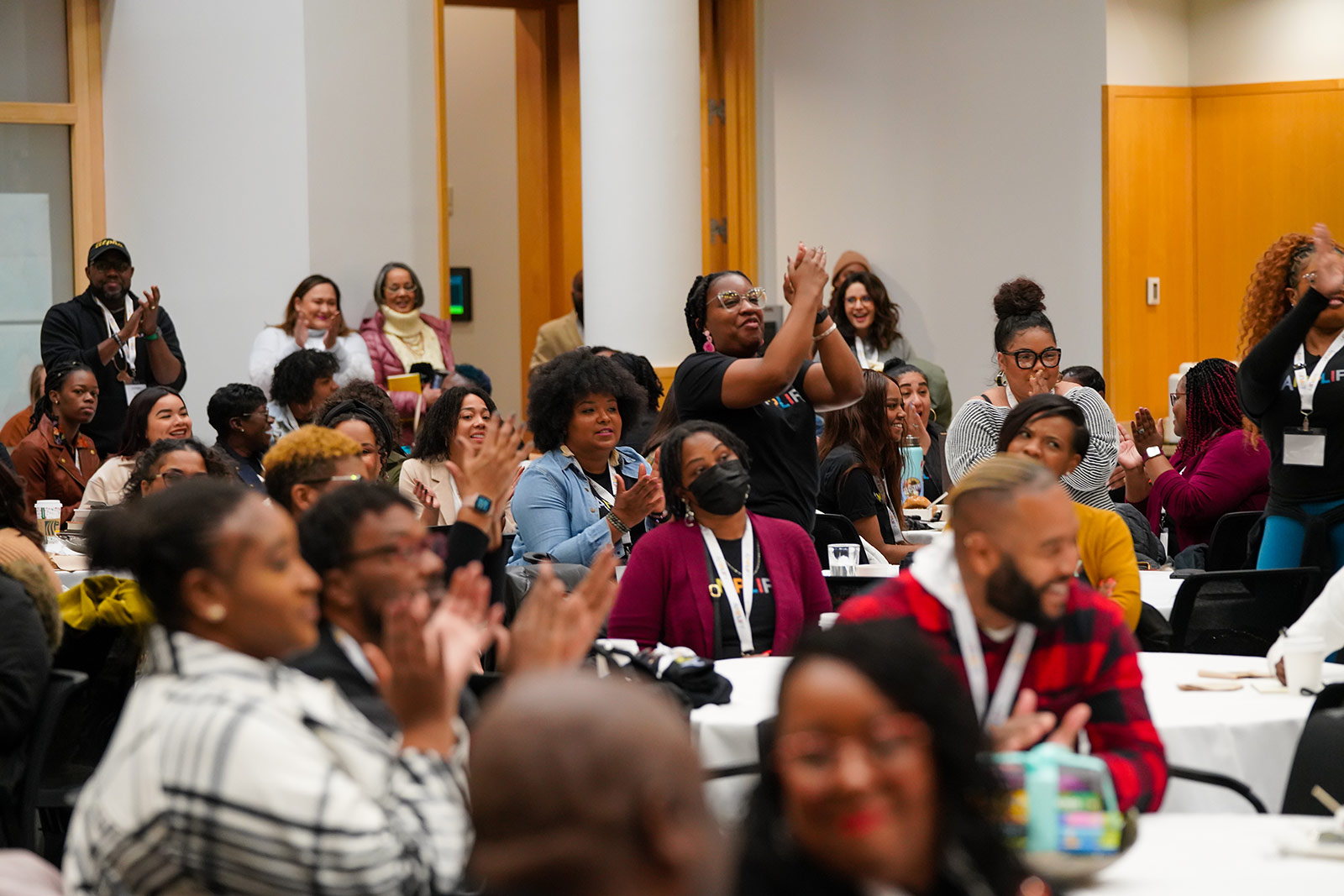 A group of conference attendees clapping. 