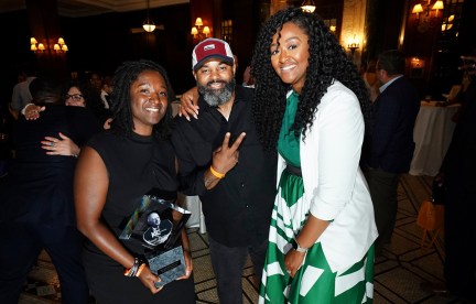 Three people pose for a photo at the Greater Kansas City Chamber of Commerce Small Business Celebration: Fahteema Parrish, left, holds the "Mr. K Award" in her hands; Daniel Smith stands in the center; and Shakia Webb is to the right.