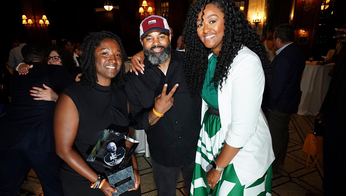 Three people pose for a photo at the Greater Kansas City Chamber of Commerce Small Business Celebration: Fahteema Parrish, left, holds the "Mr. K Award" in her hands; Daniel Smith stands in the center; and Shakia Webb is to the right.