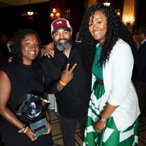 Three people pose for a photo at the Greater Kansas City Chamber of Commerce Small Business Celebration: Fahteema Parrish, left, holds the "Mr. K Award" in her hands; Daniel Smith stands in the center; and Shakia Webb is to the right.