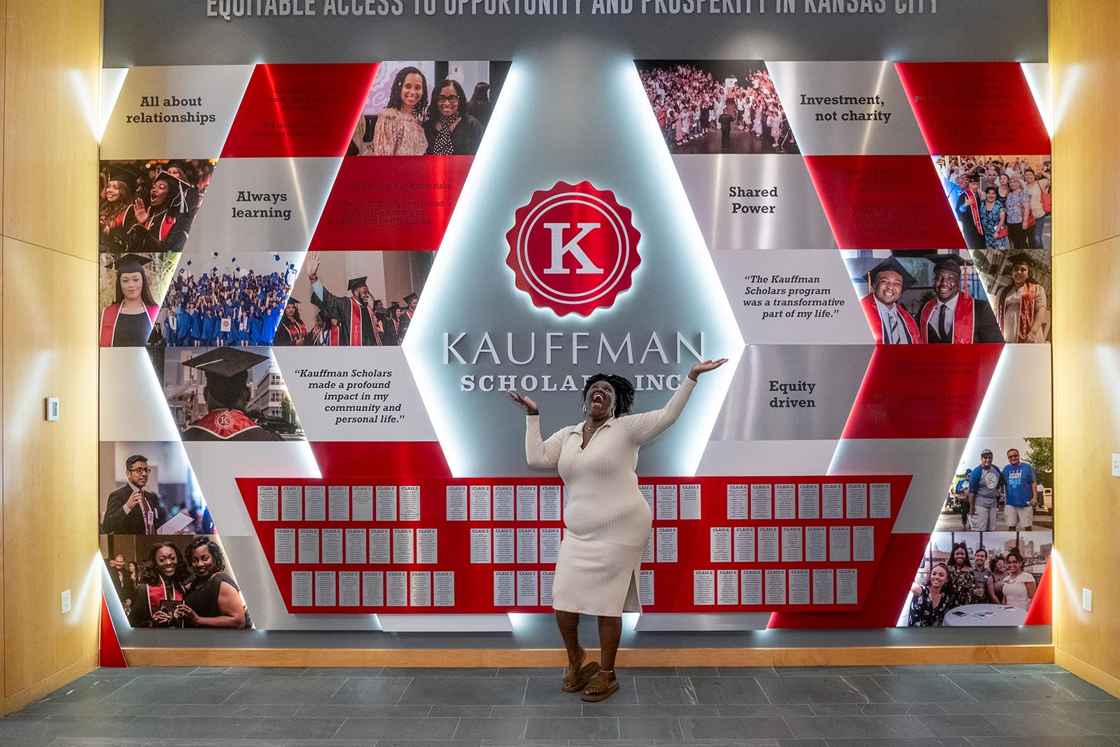 A Kauffman Scholars alum poses in front of the KSI Legacy Wall inside the Kauffman Foundation Conference Center.