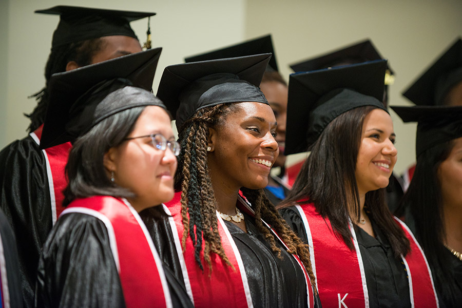 Kauffman Scholars graduates pose for a photo wearing their graduation caps, gowns, and KSI stoles.