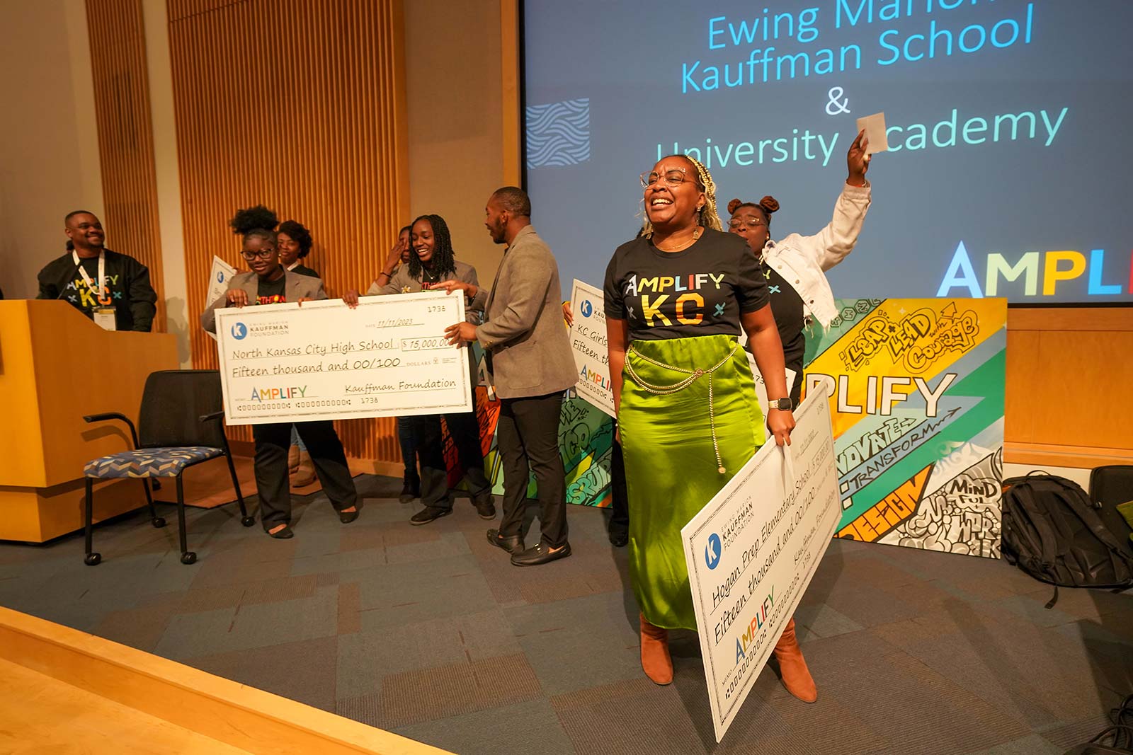 Amplify KC attendees and educators celebrate with life-sized checks during the EduTank Pitch Event