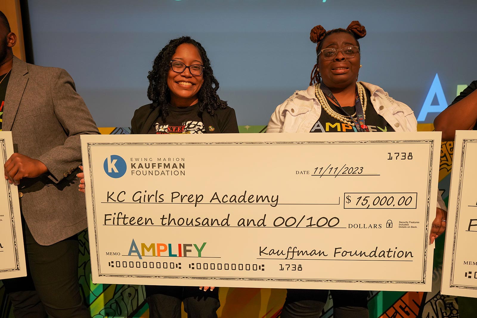 Amplify attendees hold a life-sized check made out to KC Girls Prep Academy for $15,000 from the Kauffman Foundation