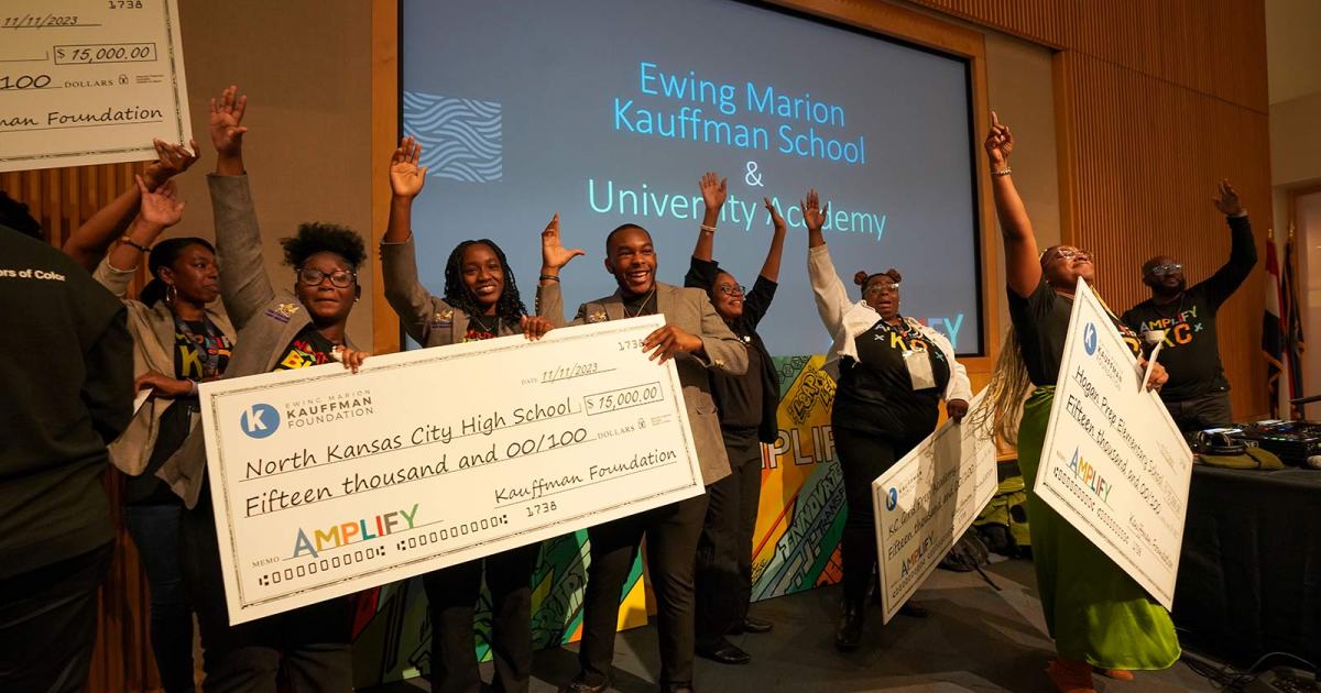 Educators and students from Brookside Charter School, Hogan Preparatory Academy, Kansas City Girls Preparatory Academy, and North Kansas City High School celebrate with life-sized checks at the 2023 Amplify Conference.