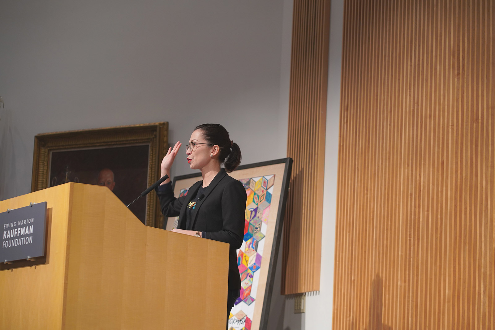 Facilitator stands at a podium during Amplify 2020 conference