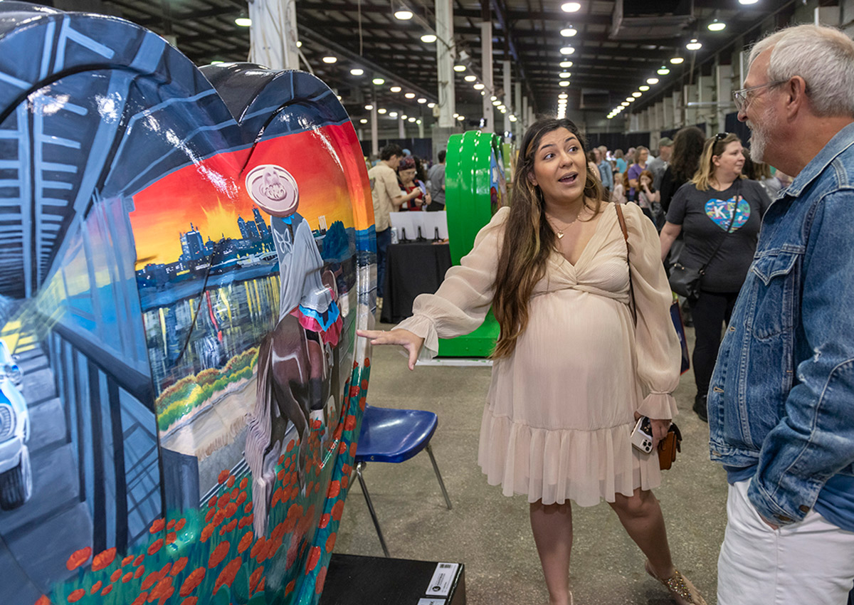 Laura Flores speaks about her heart, 'Home is Where the Heart Is/El Hogar es Donde Está el Corazón' with an attendee at the American Royal Governor's Expo event on April 13.