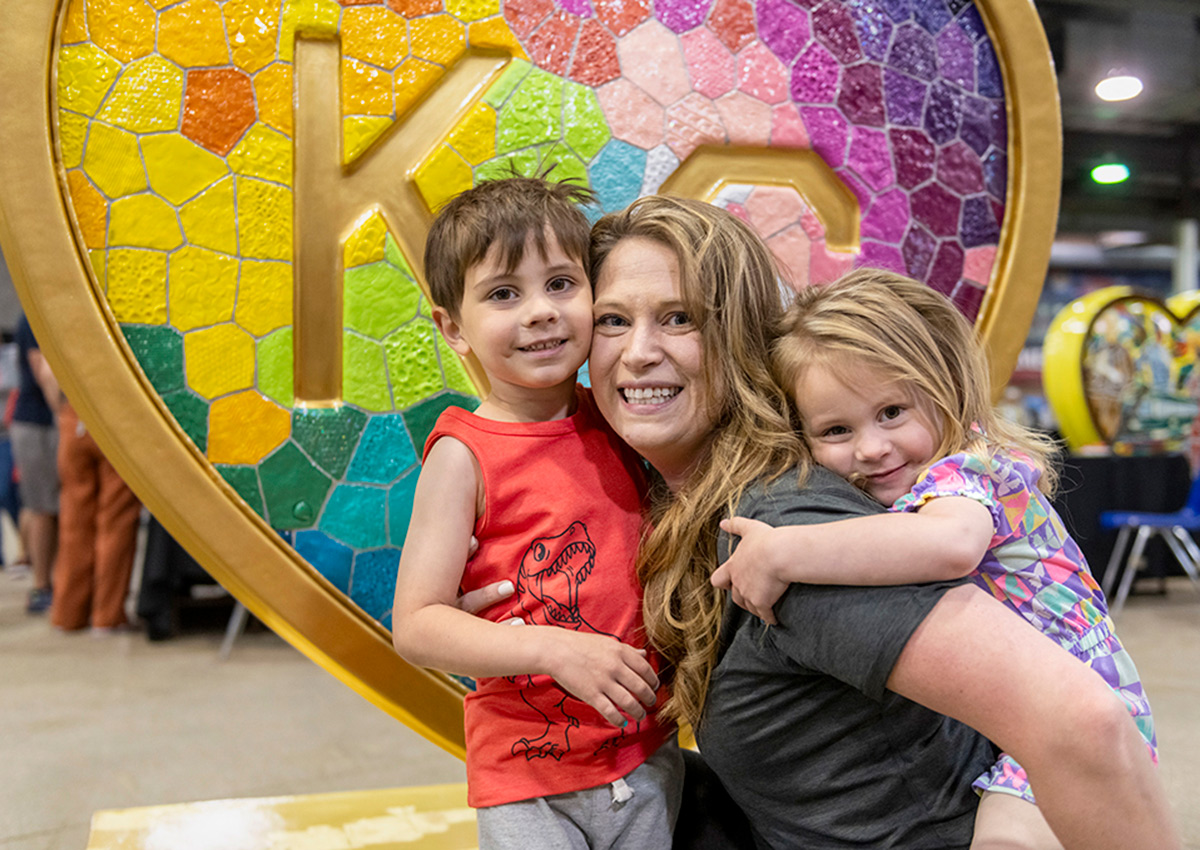 Laura Noll Crossley poses with her kids in front of her heart, 'Takes Heart', at the American Royal Governor's Expo event on April 13.