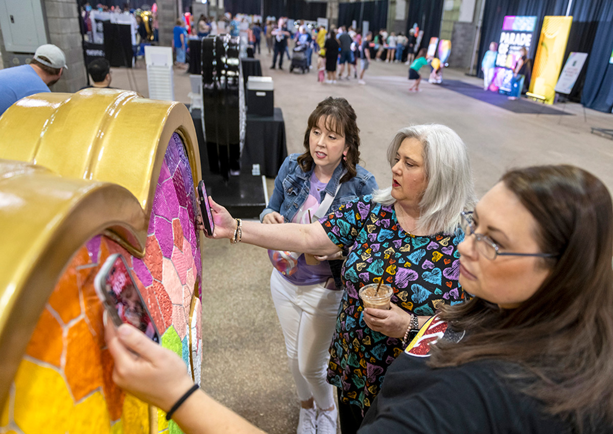 Attendees scan the QR codes embedded within Laura Noll Crossley's heart, 'Takes Heart', during the Parade of Hearts reveal event on April 13.