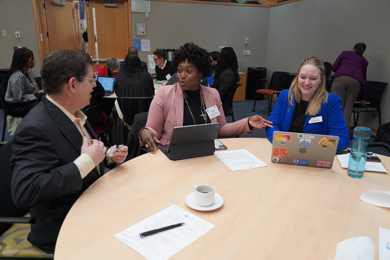 Three people in conversation at a round table