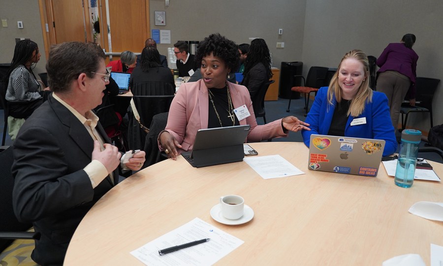 Three people in conversation at a round table
