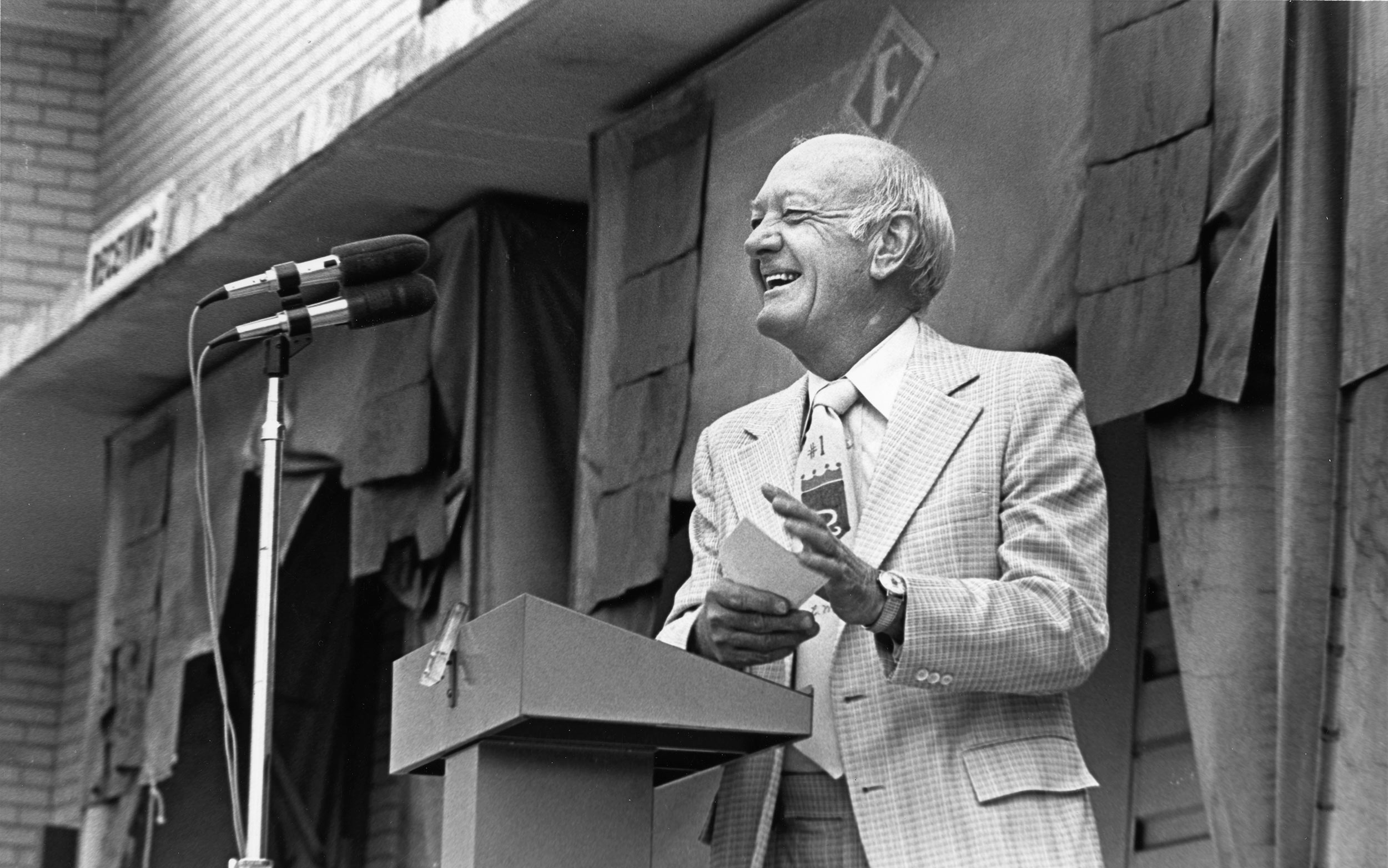 Ewing Marion Kauffman stands at a podium