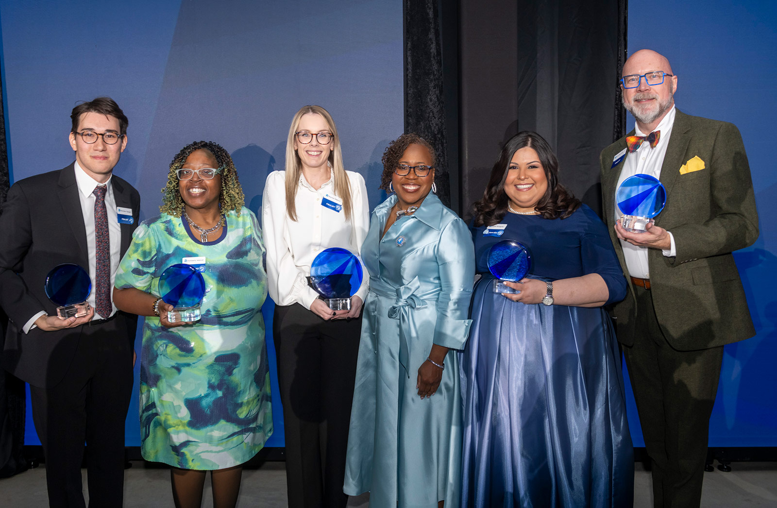 Uncommon Leader Impact Award finalists pose with their awards and the president and CEO of the Kauffman Foundation