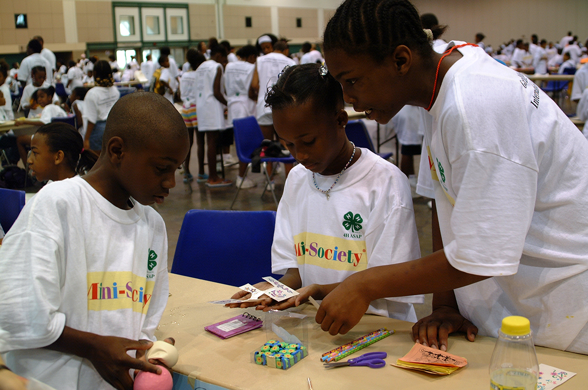 Three young adults work together on an activity at the Grand Mini-Society International Exchange Day hosted by the University of Missouri.