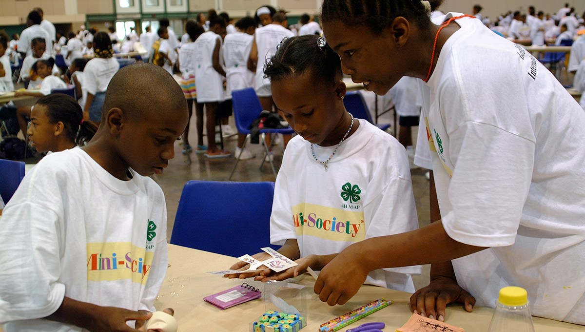 Three young adults work together on an activity at the Grand Mini-Society International Exchange Day hosted by the University of Missouri.