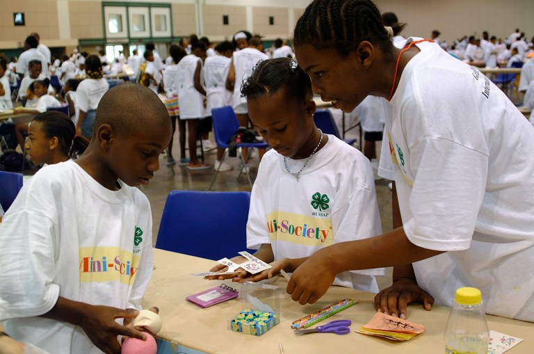 Three young adults work together on an activity at the Grand Mini-Society International Exchange Day hosted by the University of Missouri.
