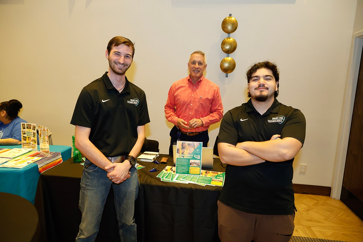 Two Smart Pro Technologies employees pose for a photo with a third individual